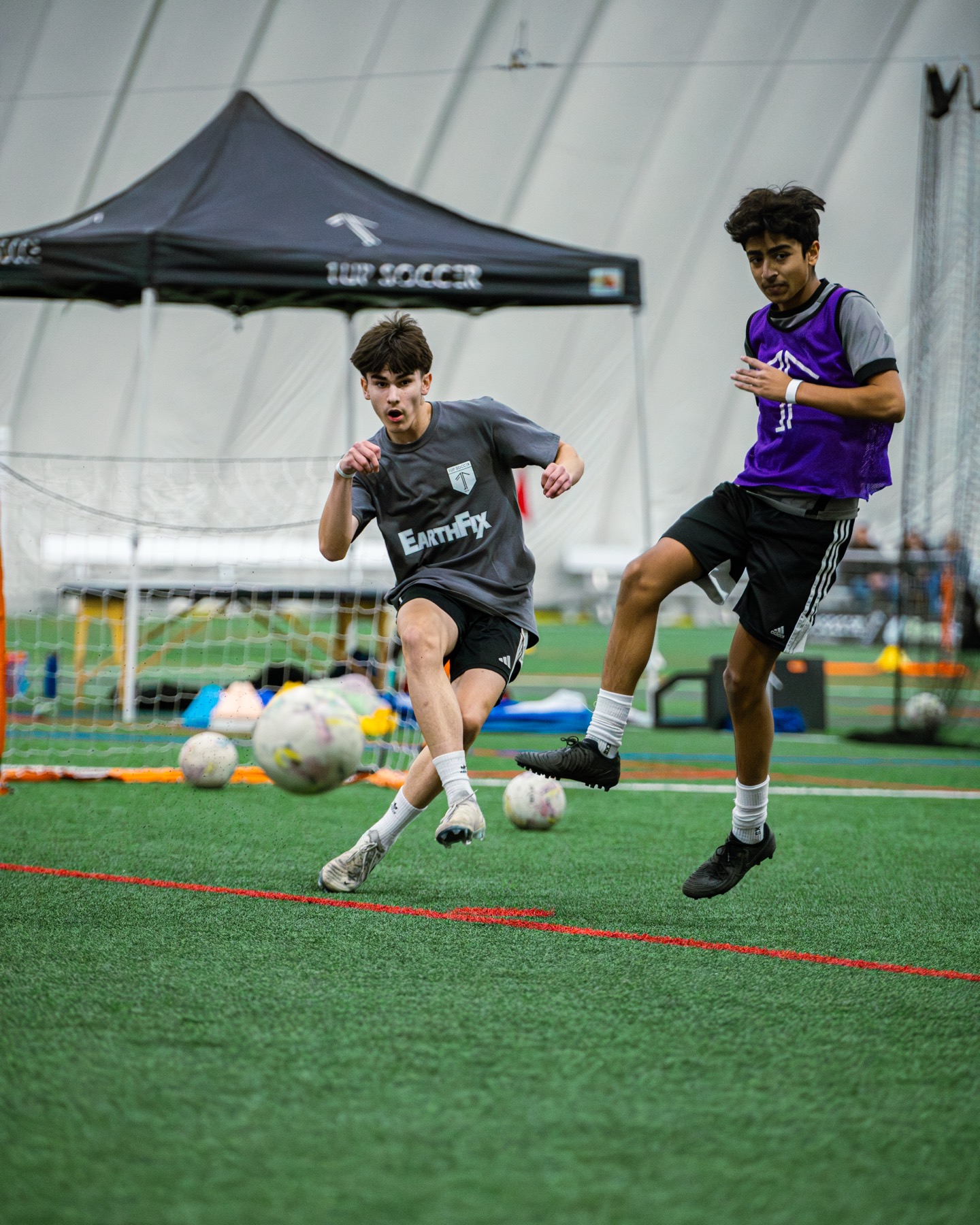 Older 1UP Soccer players in competitive action during an indoor training session