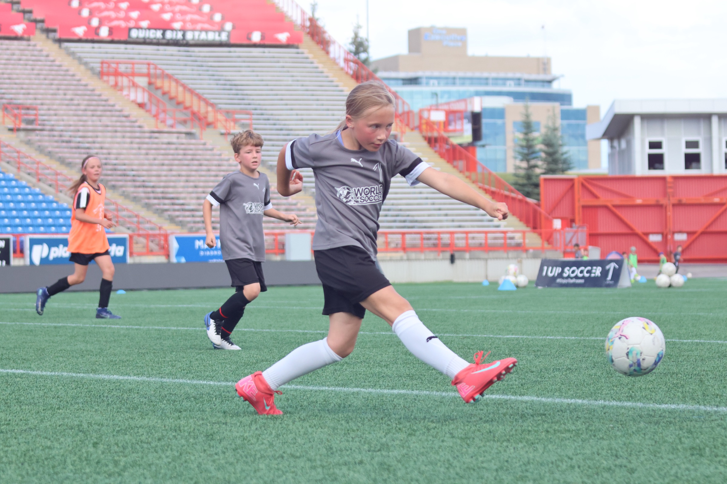 Youth soccer player striking the ball at a Calgary stadium during a 1UP Soccer training session